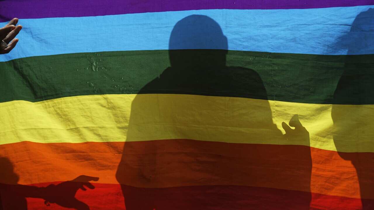 A silhouette on a LGBTIQ+ flag.