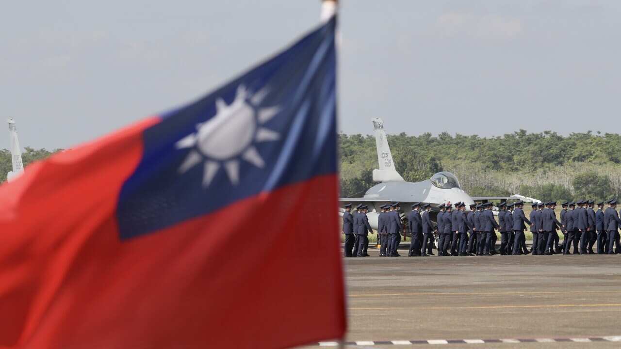 Taiwan Air Force officers march next to F-16V fighter jets at the tarmac during the commission ceremony inside the airbase of Chiayi, Taiwan, 18 November 2021.