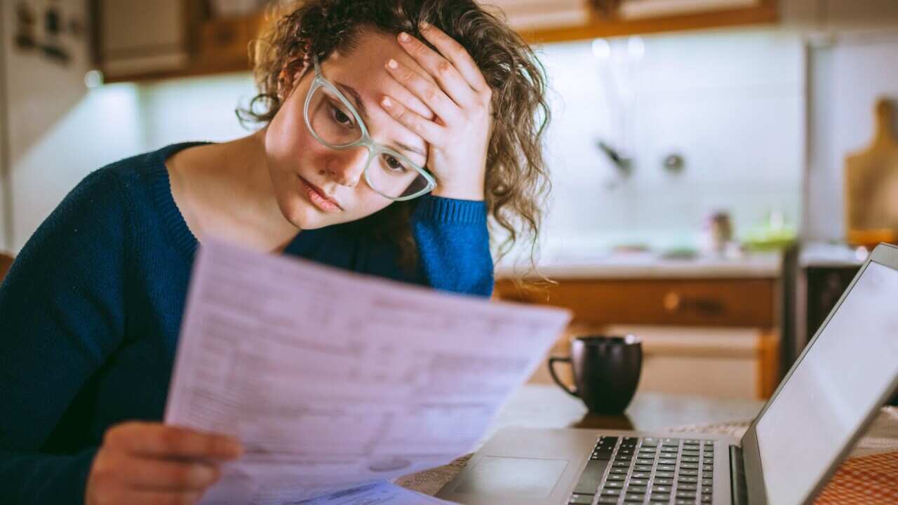 Woman going through bills, looking worried