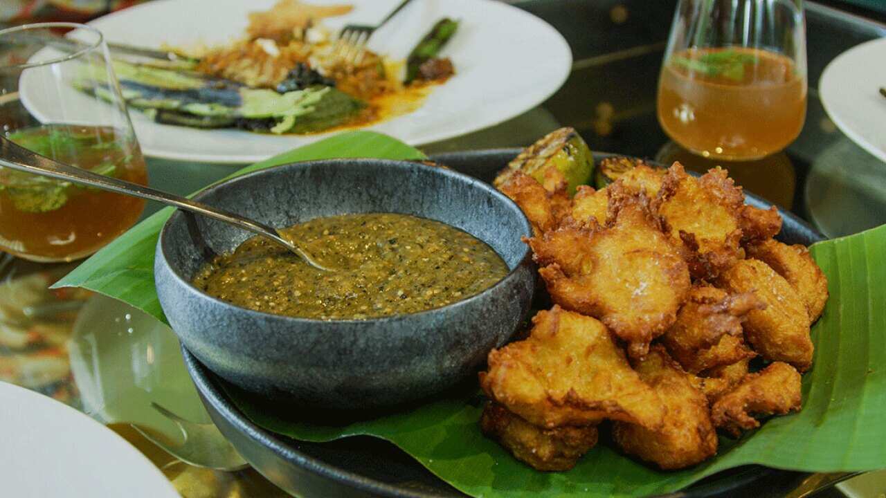 Corn and fufu fritters on banana leaf, burnt limes, chili salt 