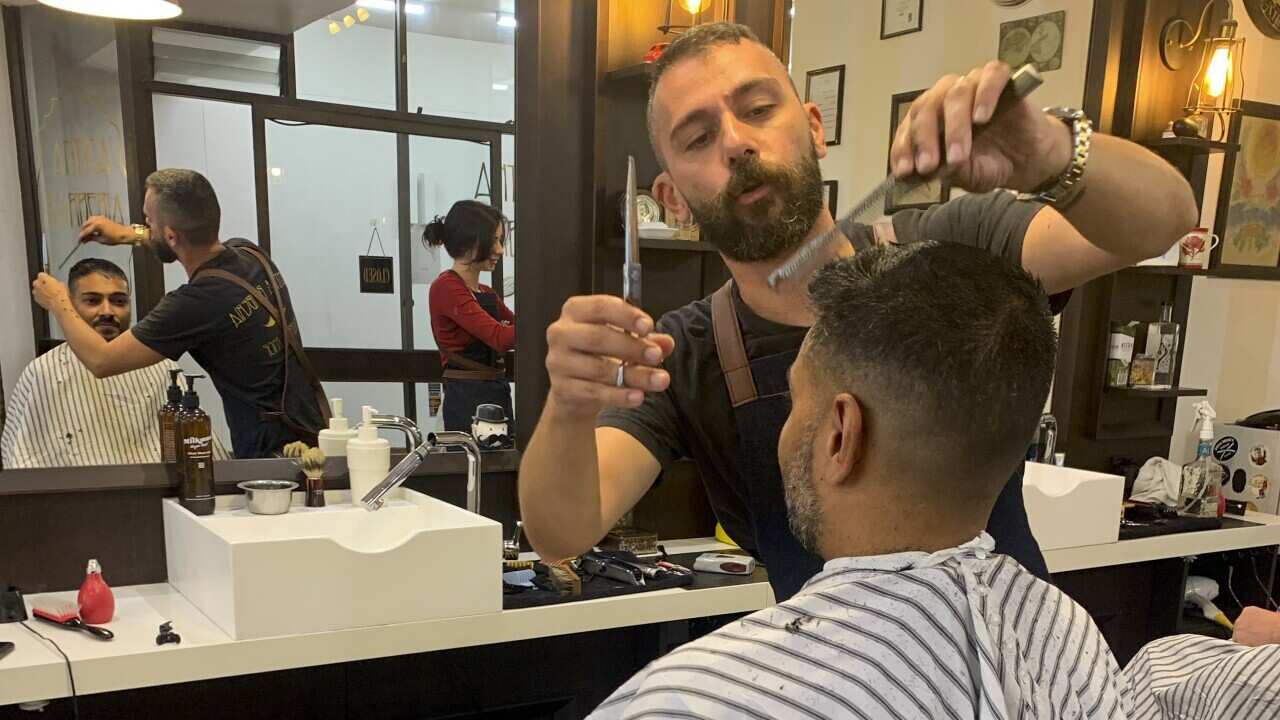 Gian cutting Jason's hair, one of his most loyal customers