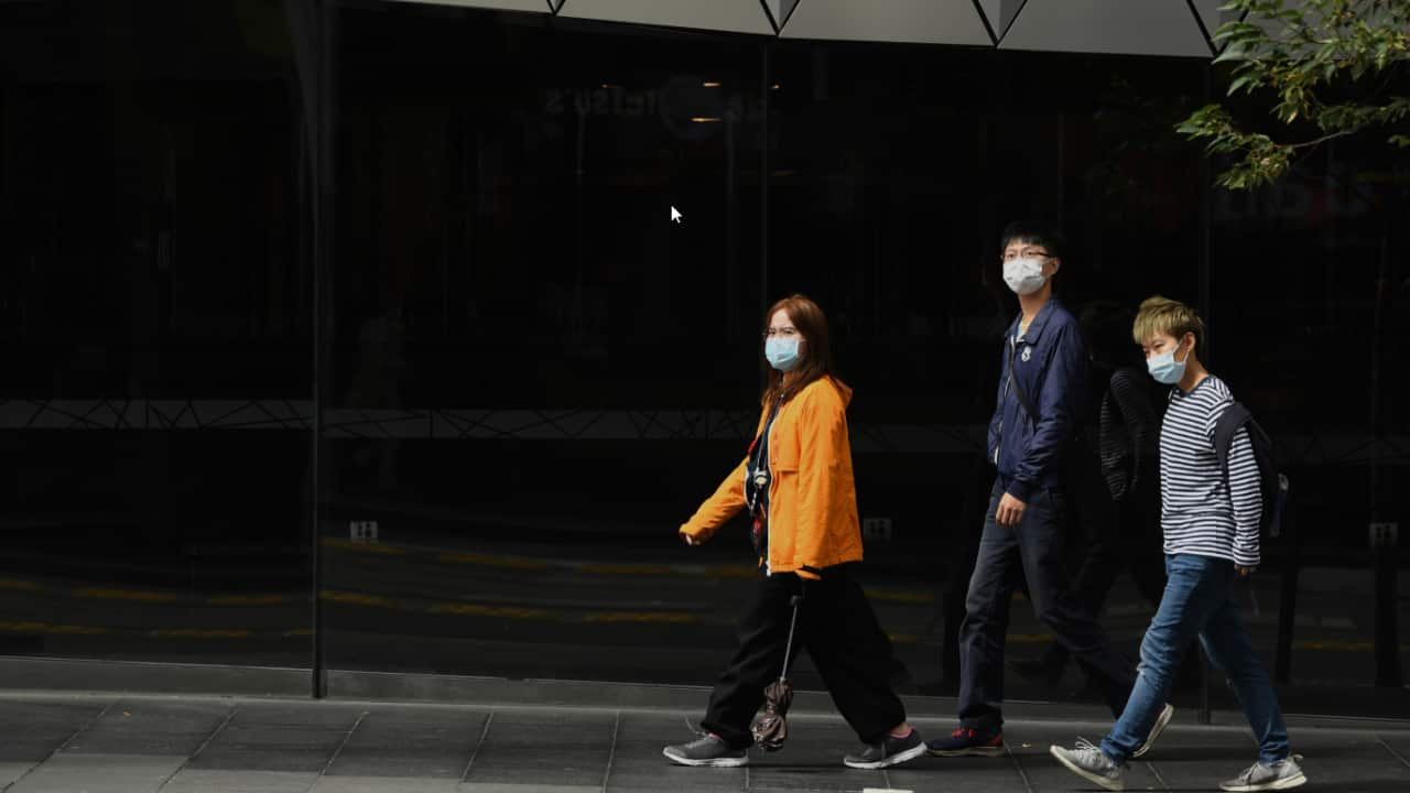 Pedestrians wear face masks in Sydney.