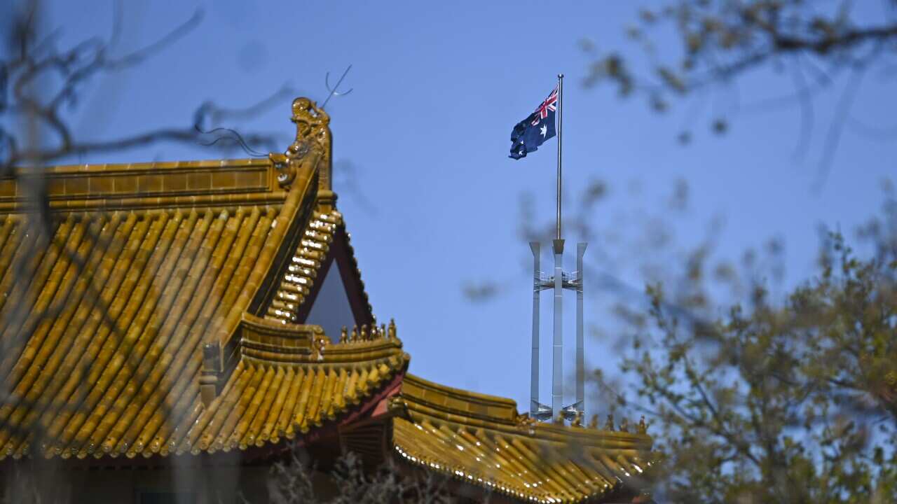 The flag pole of the Australian Parliament is seen behind the roof of the Chinese Embassy in Canberra.