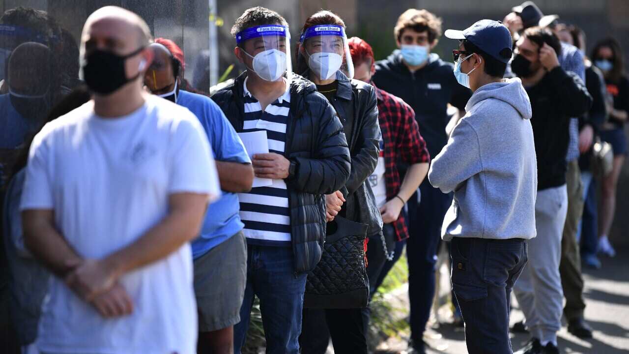 People wearing face masks waiting in a line