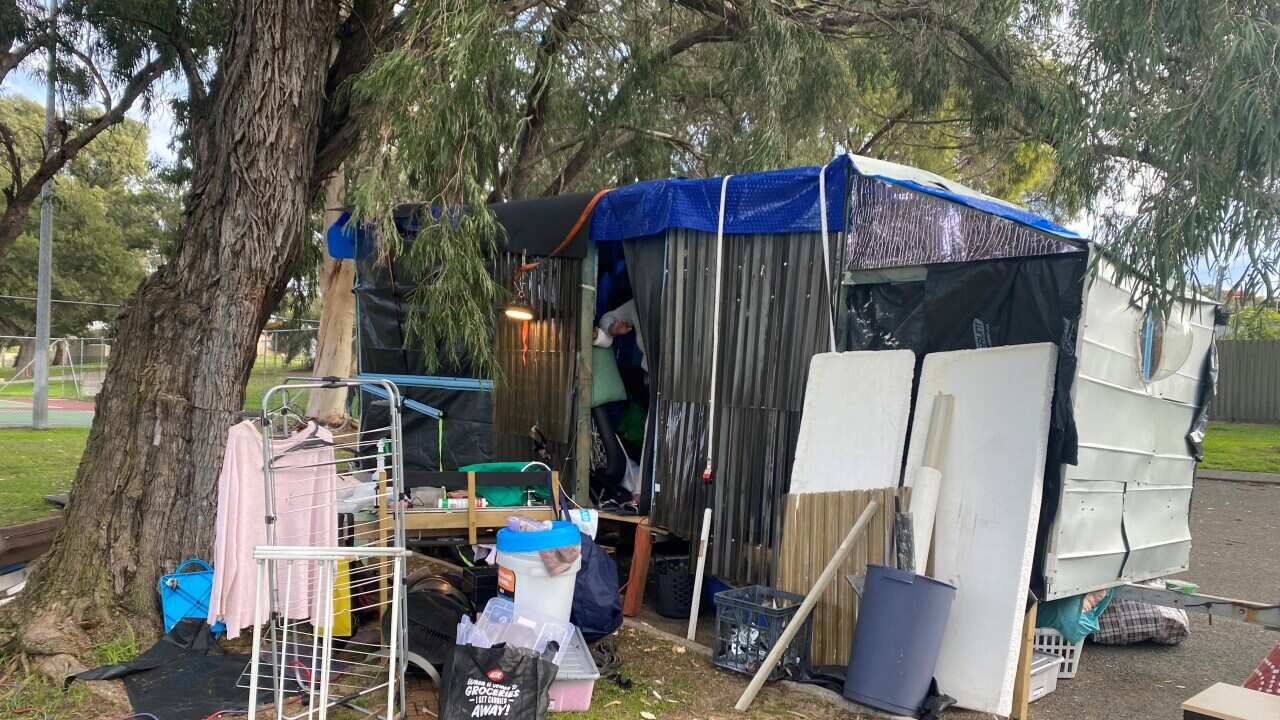 A makeshift shelter set up in a carpark next to tennis courts in suburban Perth.