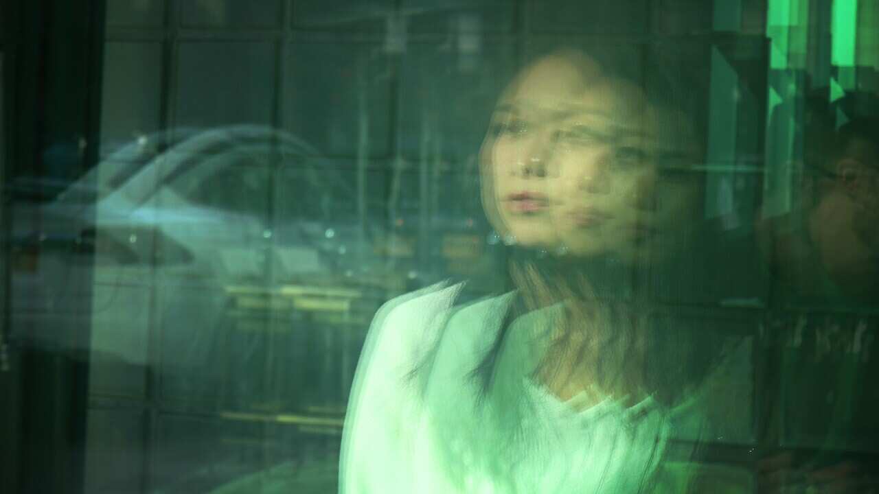 Blurred Motion Of Young Woman Seen Through Window