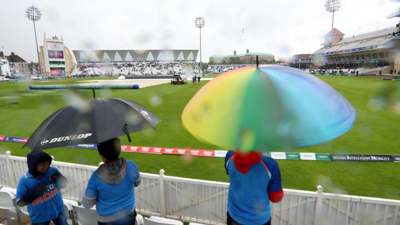 Fans brave the weather during the ICC Cricket World Cup group stage match at Trent Bridge, Nottingham.