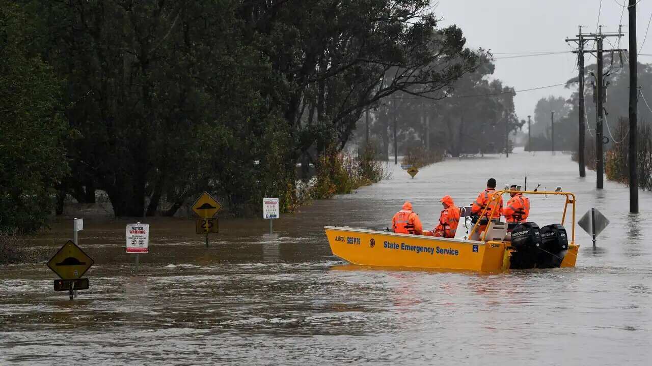 A NSW State Emergency Service (SES) crew is seen in a rescue boat as roads are submerged under floodwater from the swollen Hawkesbury River, in Windsor, northwe