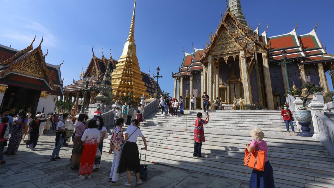Tourists wearing facemasks as a preventive measure against the spread of coronavirus are seen at the Emerald Buddha Temple inside the Grand Palace in Bangkok.
