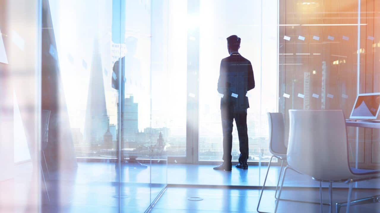 Businessman looking out of office over city