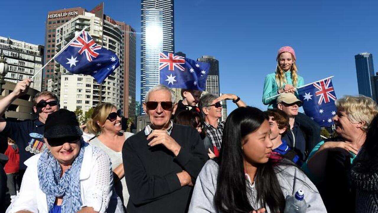 Crowds waving Australian flags watch veterans march to the Shrine of Remembrance for the Anzac Day march in Melbourne (AAP) 