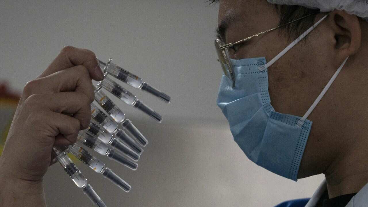 A worker manually inspects syringes of the SARS CoV-2 Vaccine for COVID-19 produced by Sinovac at its factory in Beijing.