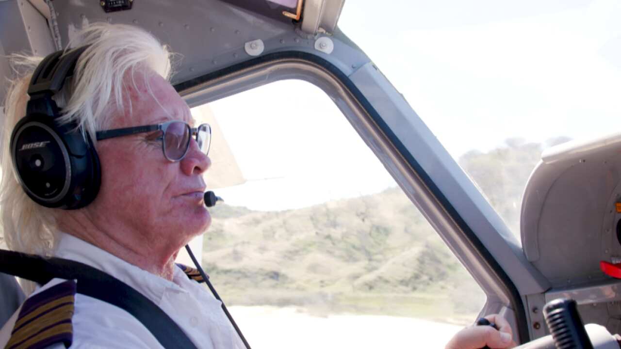 an older man flying a plane