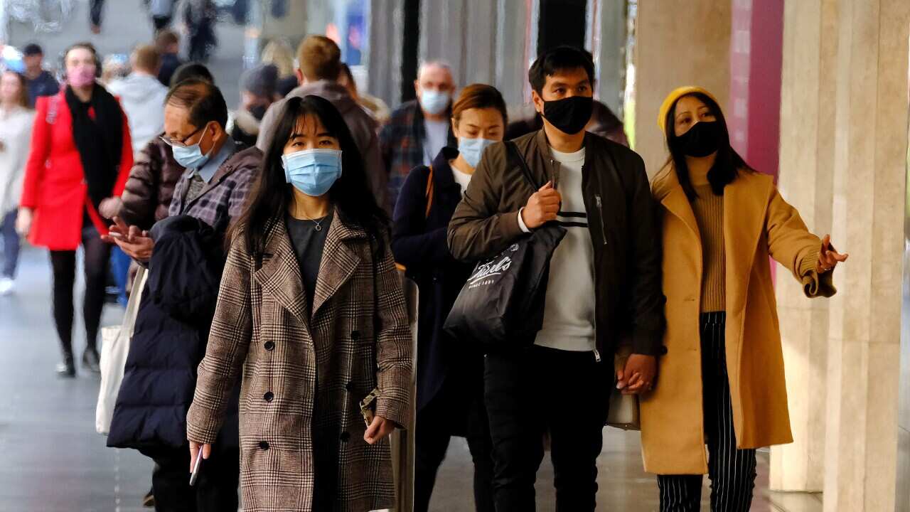 People wearing face masks walk in the Melbourne CBD, Thursday, July 15, 2021. Victoria has reported two new locally acquired COVID-19 cases, on top of the 10 reported in Thursday's official figures. (AAP Image/Luis Ascui) NO ARCHIVING