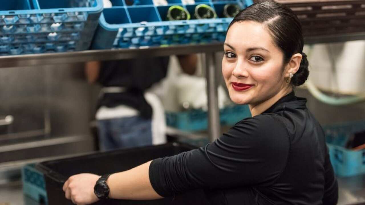 Smiling Young hispanic female kitchen worker looking at the camera Young hispanic female kitchen worker