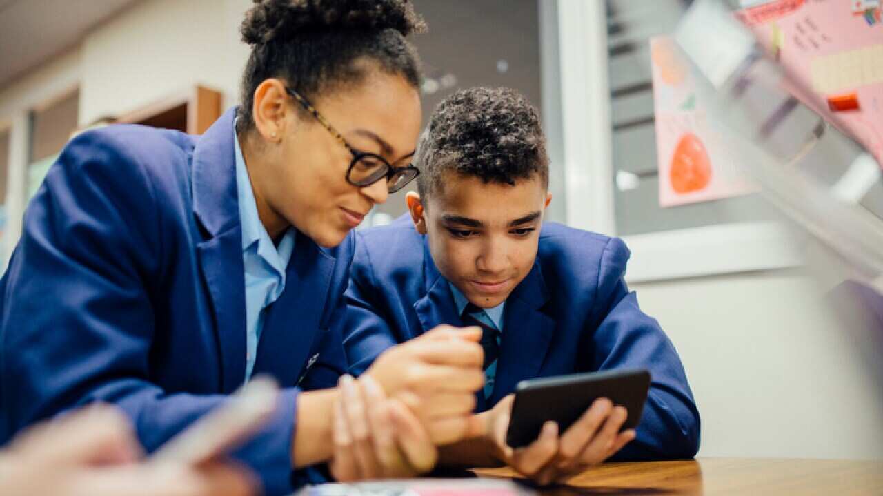 Sneaky Students Using Smartphone In Lesson