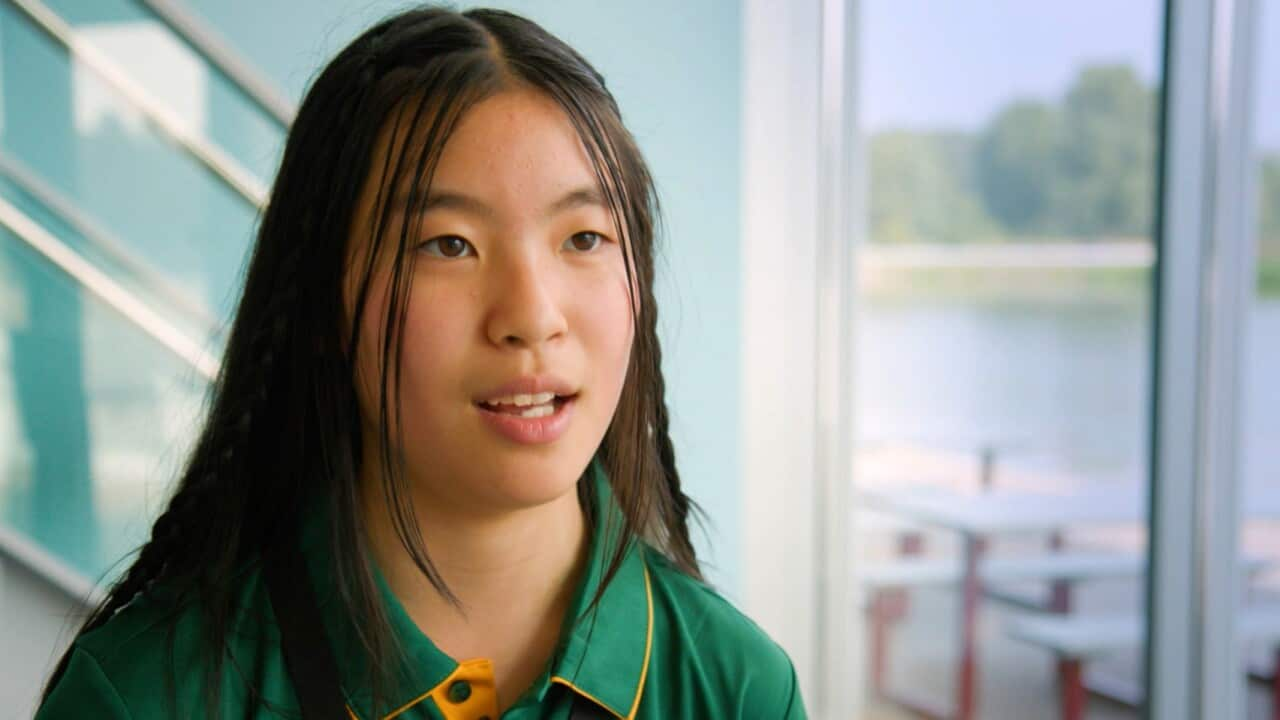 A headshot of an Asian teenage girl with long dark wearing a green polo shirt.