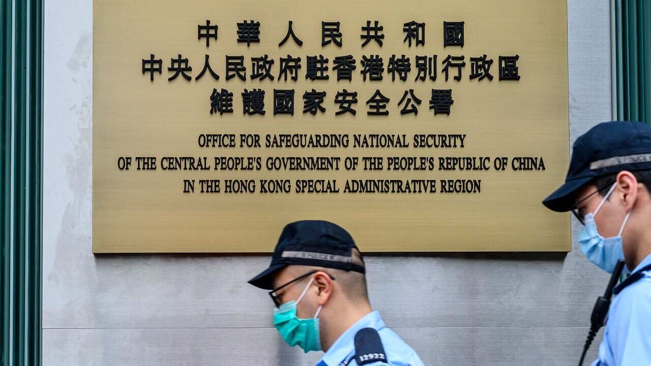 Police walk past a plaque outside the new office.