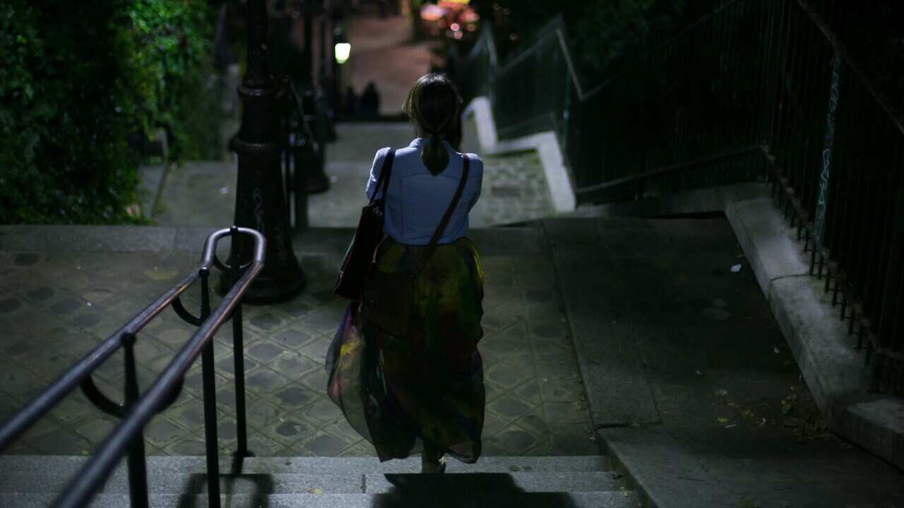 Rear View Of Woman Walking On Steps At Night