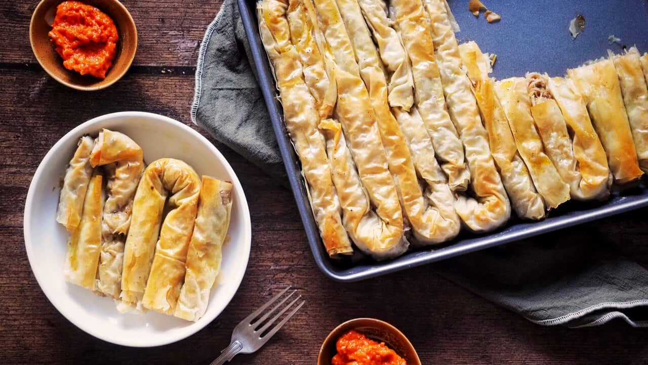 A tray of meat and potato burek served with ajvar