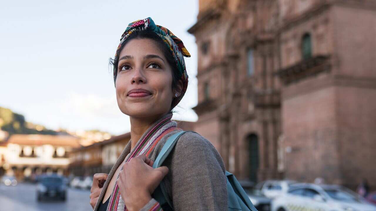 Happy woman sightseeing around Cusco around the Cathedral.