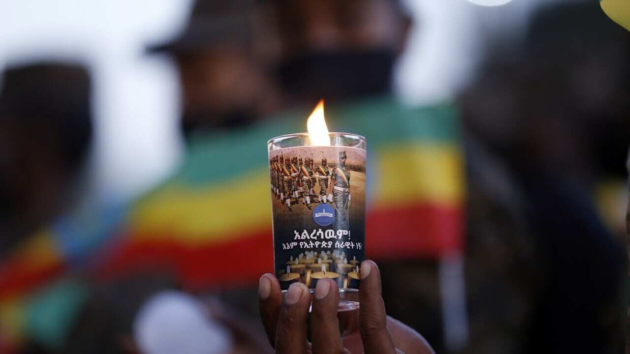 A person holds a lit candle in memory of the victims of the Tigray conflict in Addis Ababa, Ethiopia, on 3 November, 2021.