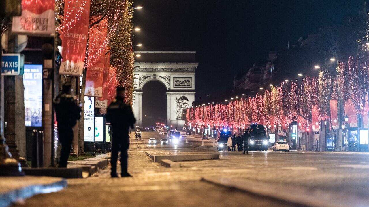 Police patrol the Champs Elysees during the curfew controls on New Year's Day in Paris, France.