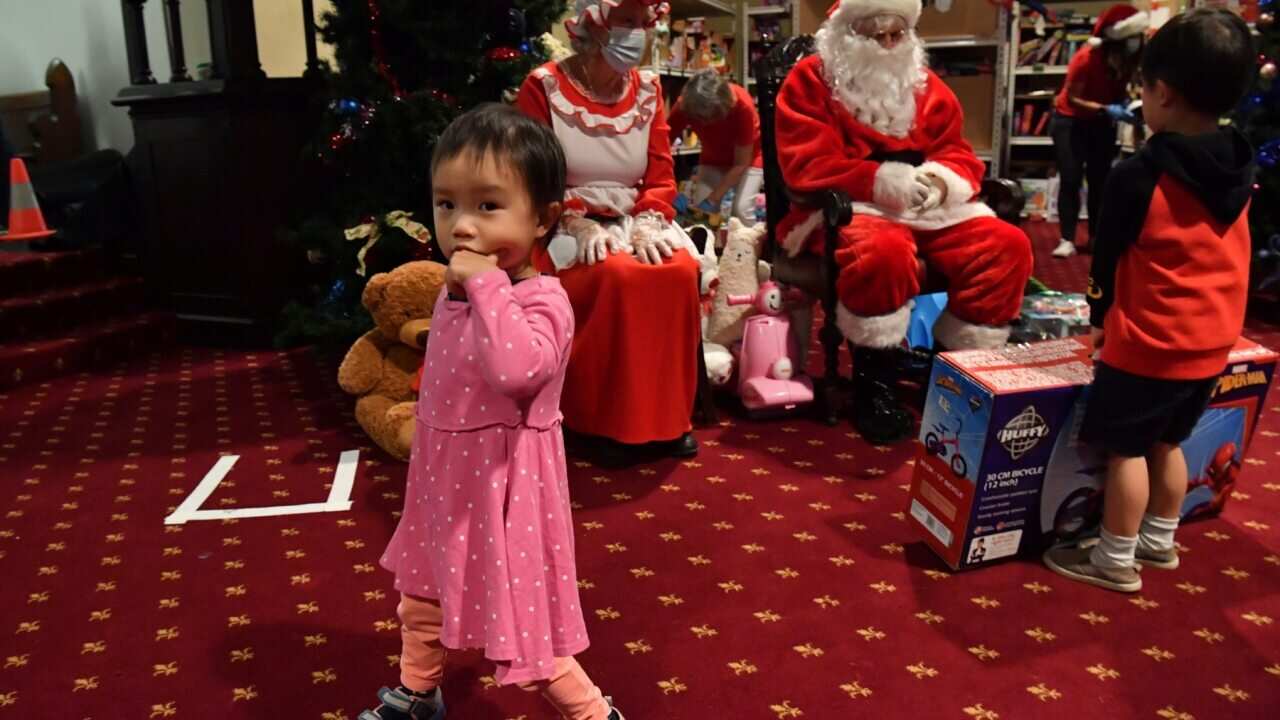 The children of needy families are give Christmas presents by Santa Clause at the Reverend Bill Crews Foundation at Ashfield in Sydney.