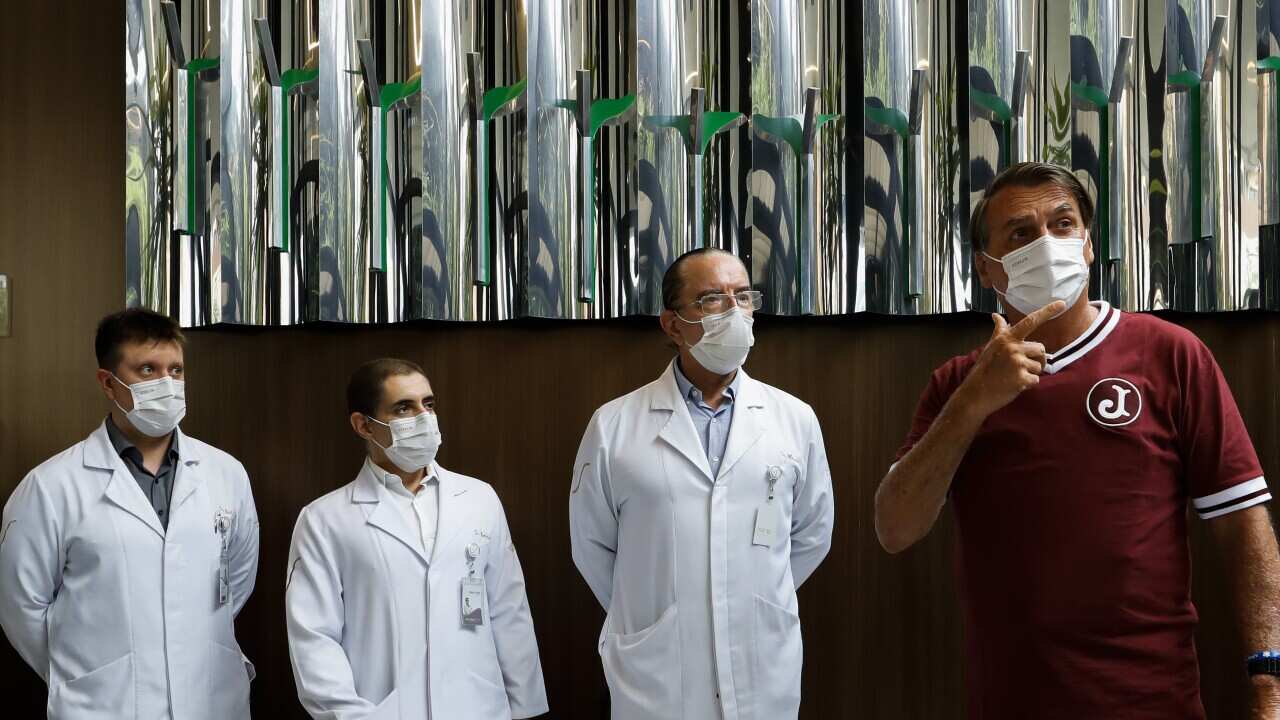 Brazilian President Jair Bolsonaro, right, gives a press conference as he is discharged from Vila Nova Star hospital in Sao Paulo