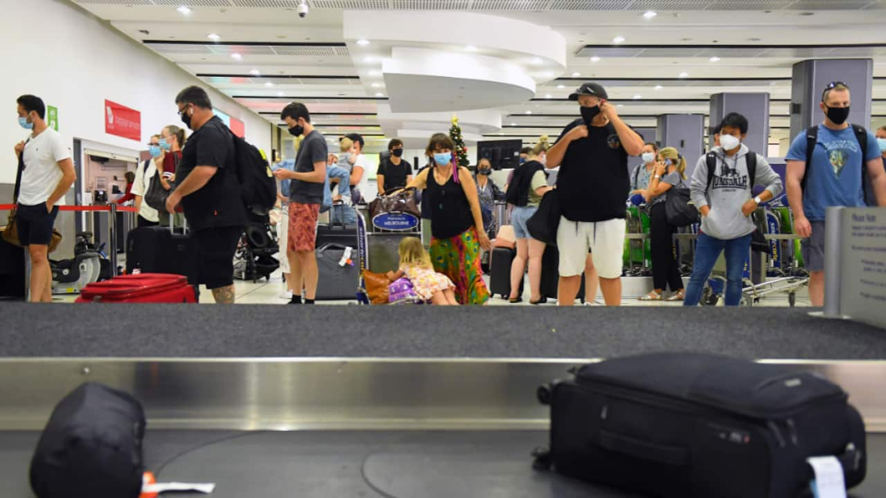 People are seen in the baggage collection area at Tullamarine Airport in Melbourne, January 8, 2021.