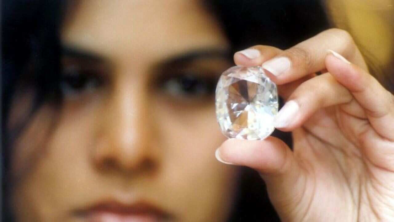 Woman holding up replica of the kohinoor diamond