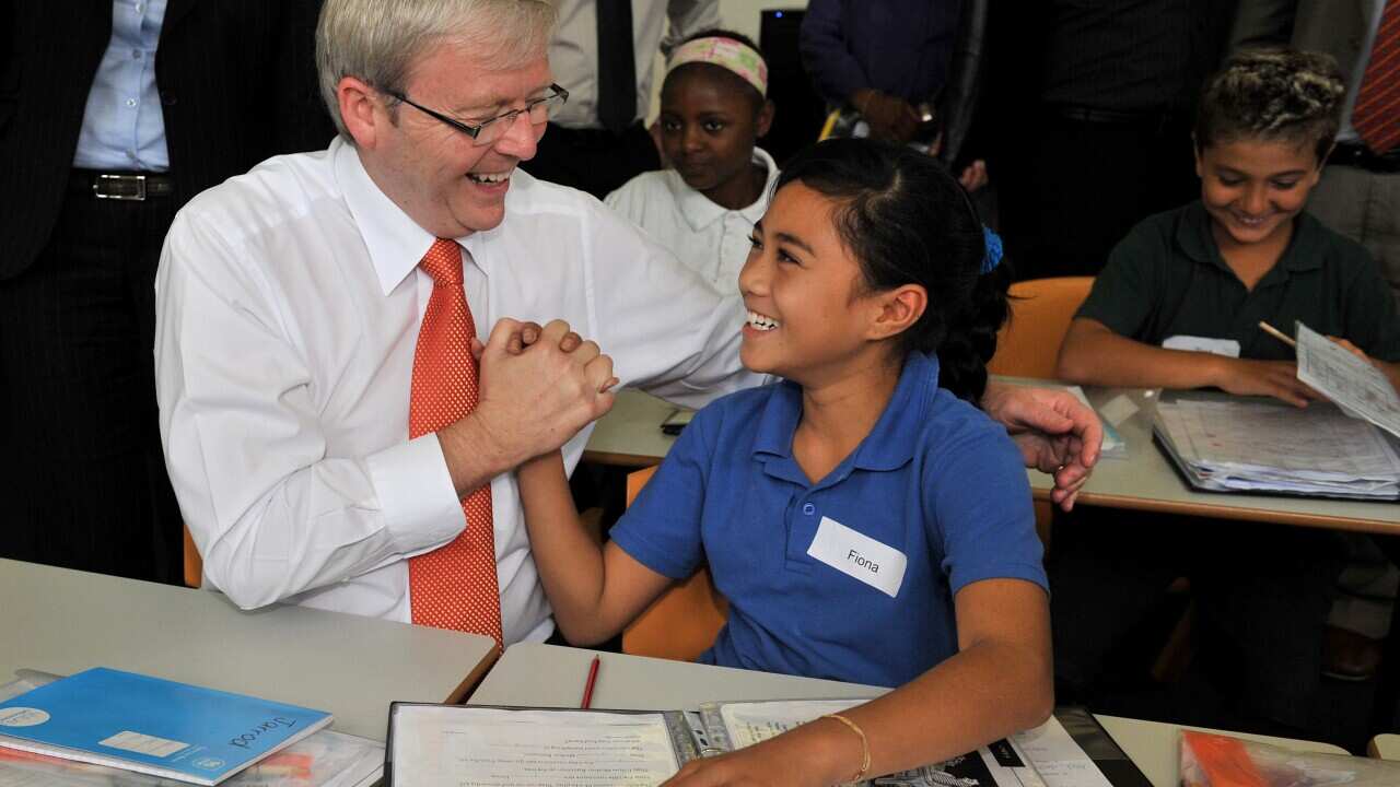 Prime Minister Kevin Rudd high fives Fiona, a student attending a literacy class, after he officially opened the National Centre of Indigenous Excellence in Sydney, on Friday, Feb. 26, 2010. (AAP Image/Paul Miller) NO ARCHIVING