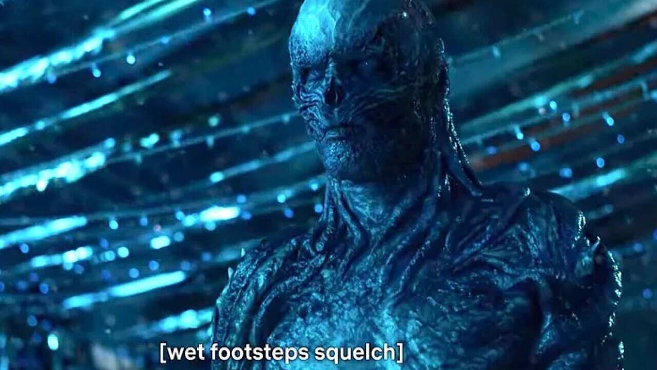 A blue, skeletel creature stares menacingly, with closed captions reading: "wet footsteps squelch"