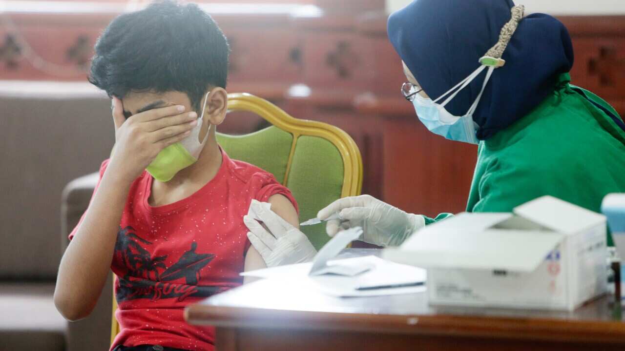 A school student receives a dose of COVID-19 vaccine 