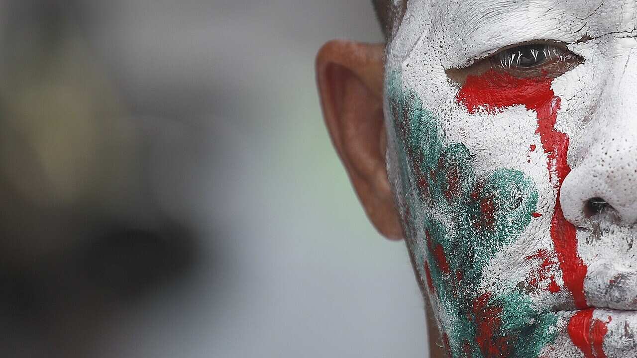 An anti-government protester with his face painted looks on during an anti-government rally at the democracy monument in Bangkok in October 2020.