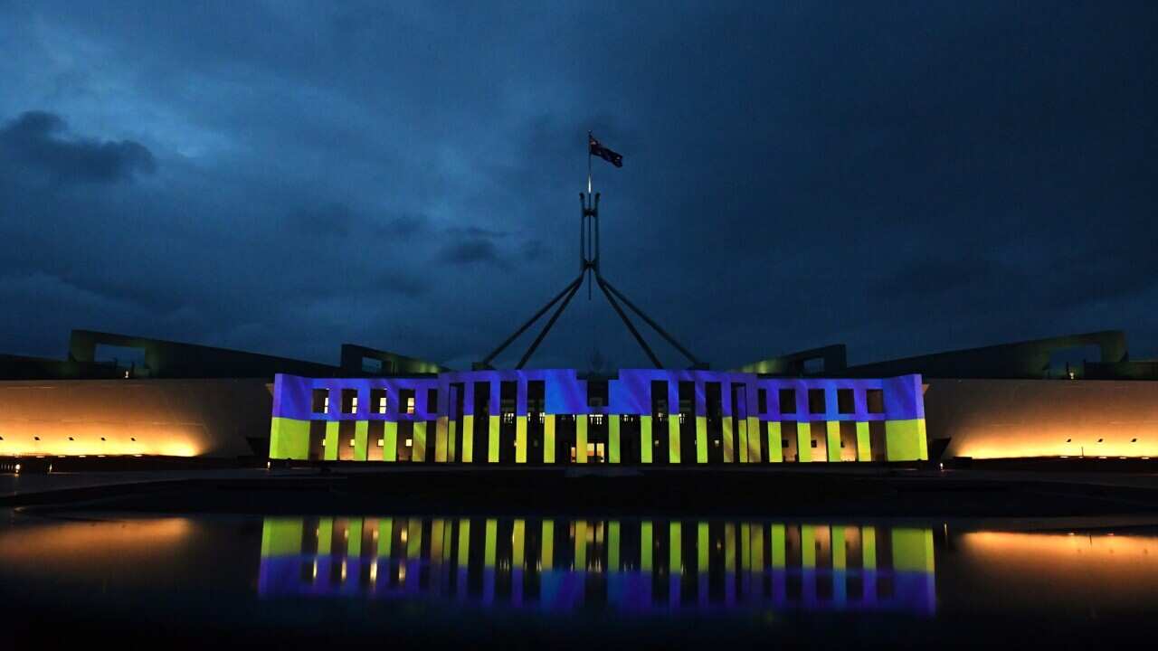 Australia’s Parliament House is illuminated with the colours of Ukraine’s flag in solidarity with the country's people and government, in Canberra, Monday, February 28, 2022. (AAP Image/Mick Tsikas) NO ARCHIVING