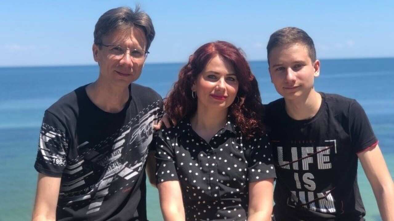 Man, woman and son in front of sea.