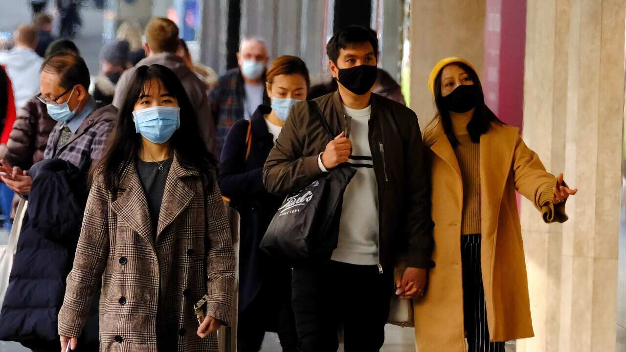 People wearing face masks walk in the Melbourne CBD, Thursday, July 15, 2021. Victoria has reported two new locally acquired COVID-19 cases, on top of the 10 reported in Thursday's official figures. (AAP Image/Luis Ascui) NO ARCHIVING