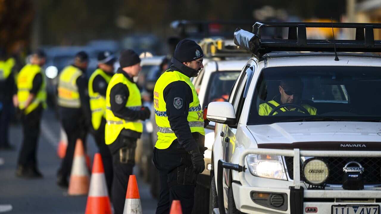 NSW Police officers check cars crossing from Victoria into New South Wales on Wednesday.