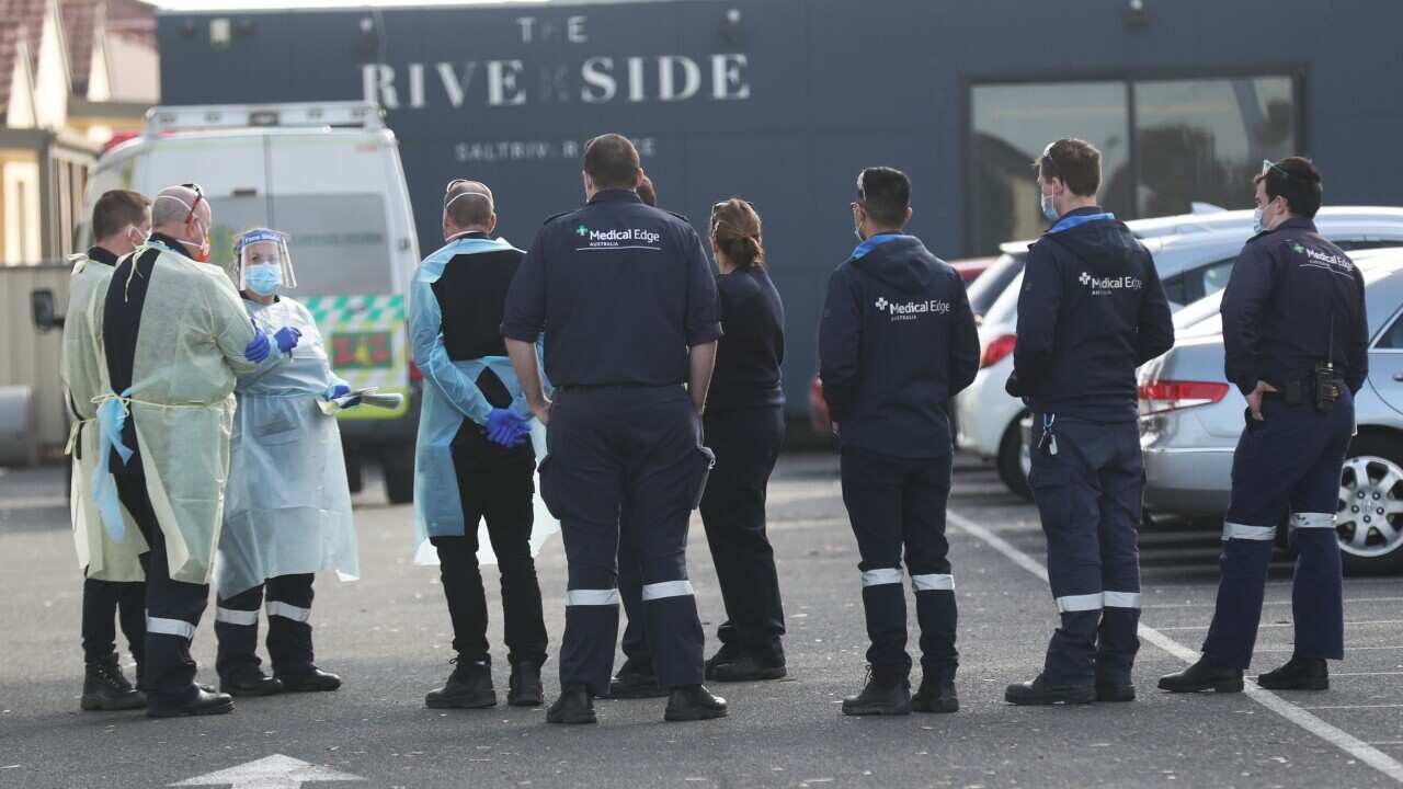 Medical staff are seen preparing to transport people from the St Basils Home for the Aged Care in Fawkner which has had an outbreak of COVID-19, Melbourne, Saturday, July 25, 2020.  Aged care facilitates in Melbourne are being affected by the virus in mul