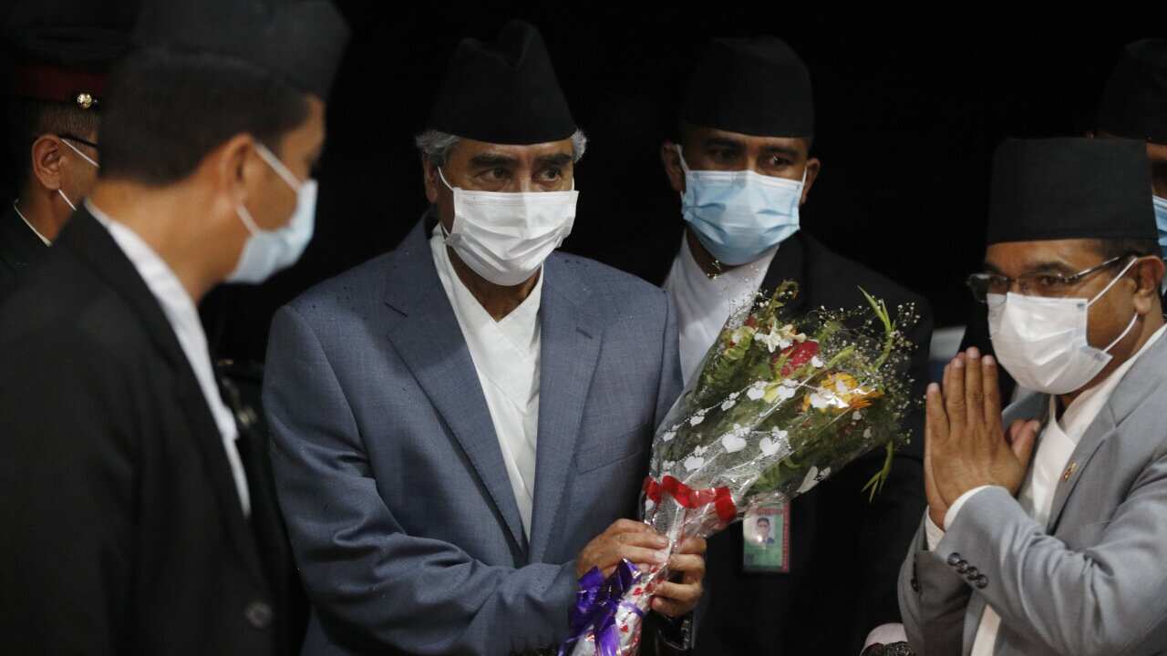 Sher Bahadur Deuba, center holding bouquet, arrives to assume office after he was sworn in as Nepal's new prime minister in Kathmandu, Nepal, Tuesday, July 13, 2021.