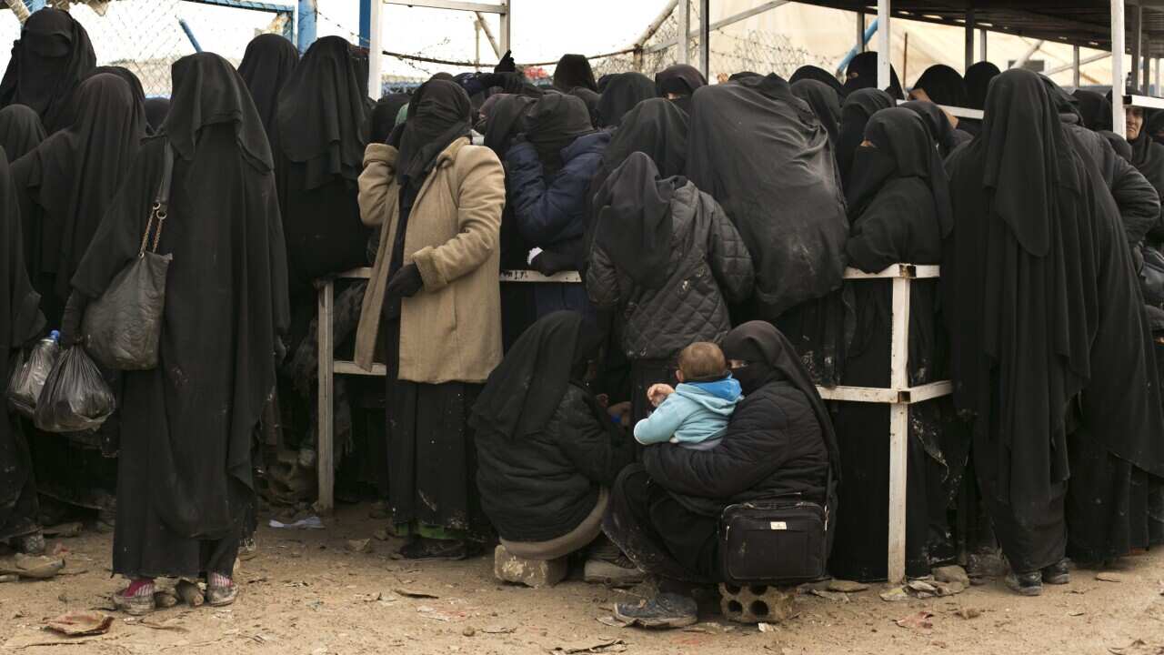 Women residents from former IS-held areas in Syria line up for aid supplies at Al-Hol camp in Hassakeh province, Syria.