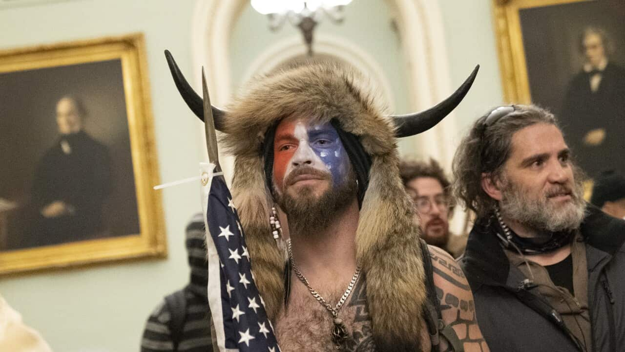 Man dressed as 'shaman', wearing a horns on his head, a fur hat and his face painted in the colours of the US flag in the US Capitol building after it was stormed on January 6, 2021.