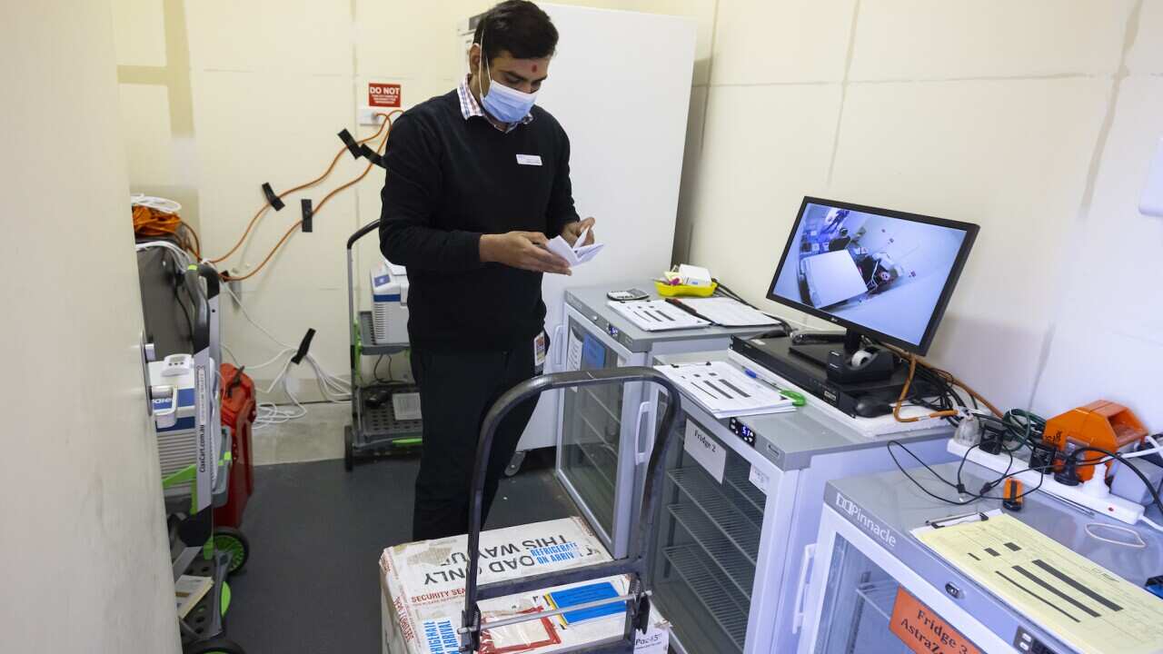 A pharmacy worker receives a temperature sensitive box with Pfizer vaccines at the Sandown Racecourse Vaccination Centre in Melbourne, Tuesday, August 31, 2021.