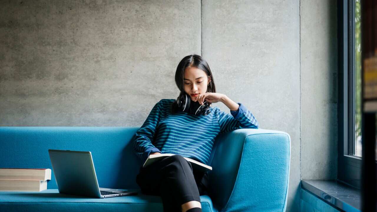 Young Woman Sitting On Couch In Library