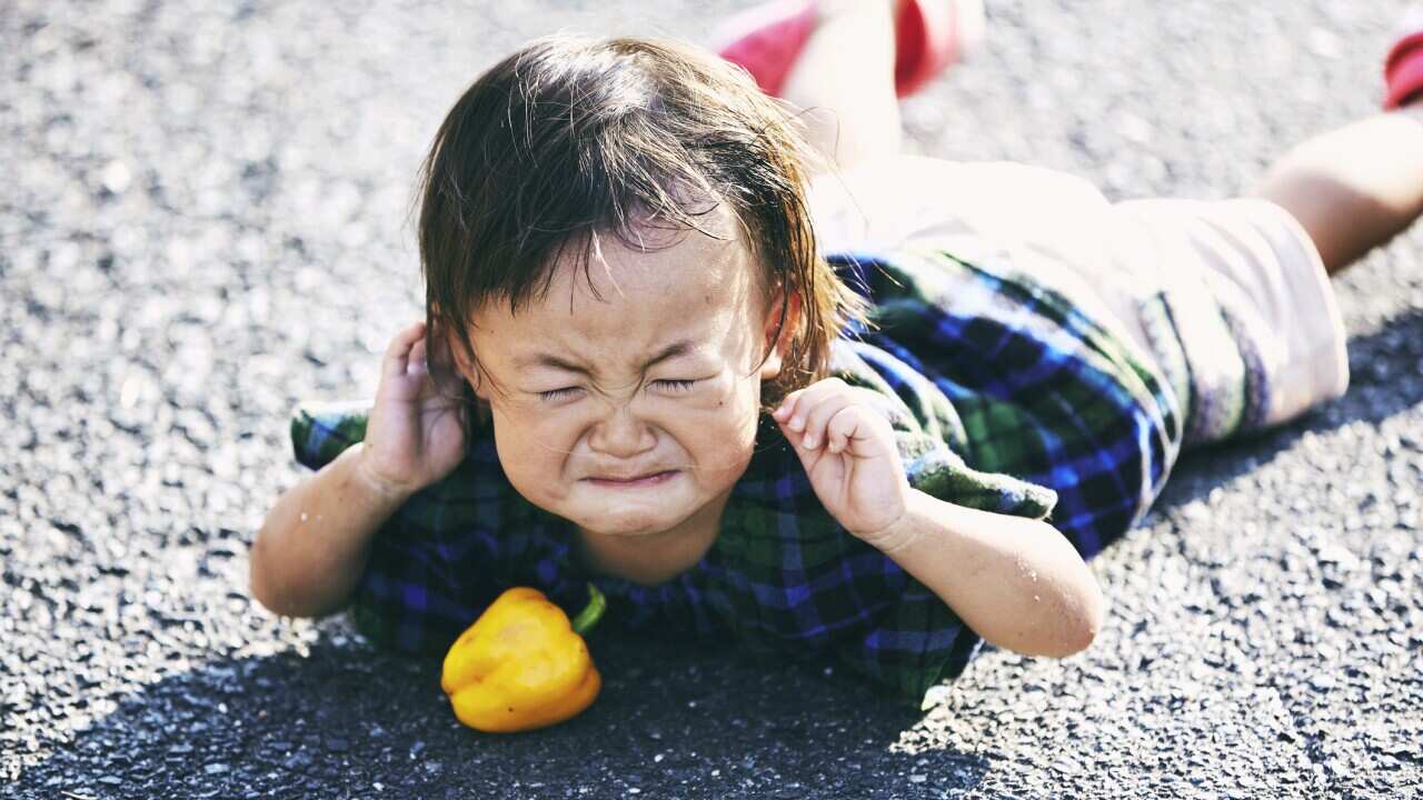 Little girl falling down and crying on the road