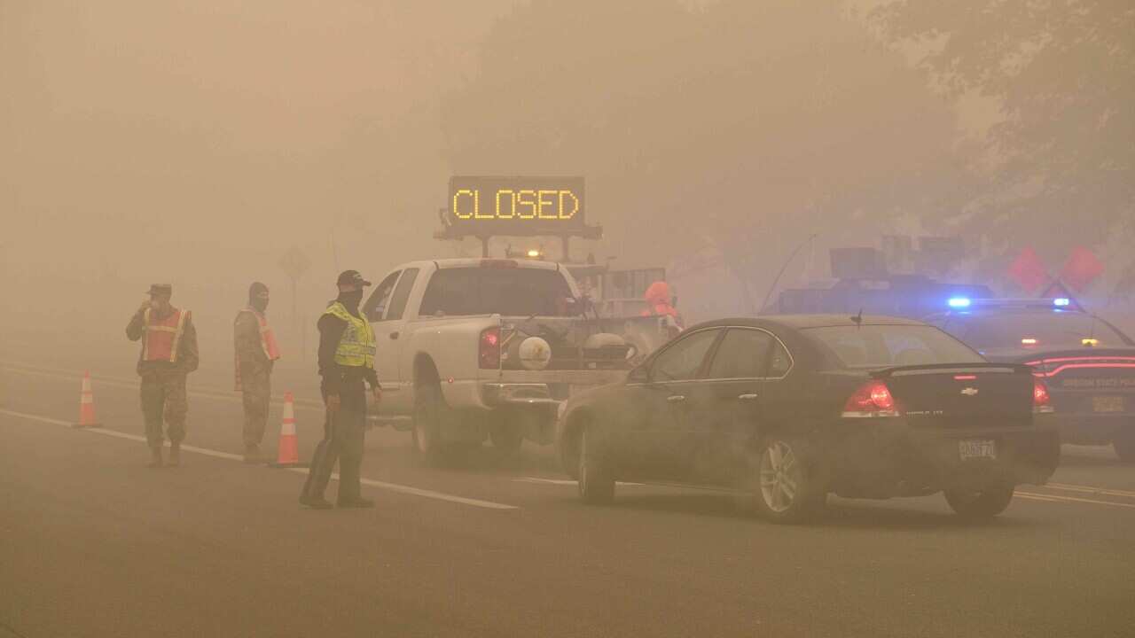 Vehicles travel through a checkpoint manned by Oregon state police