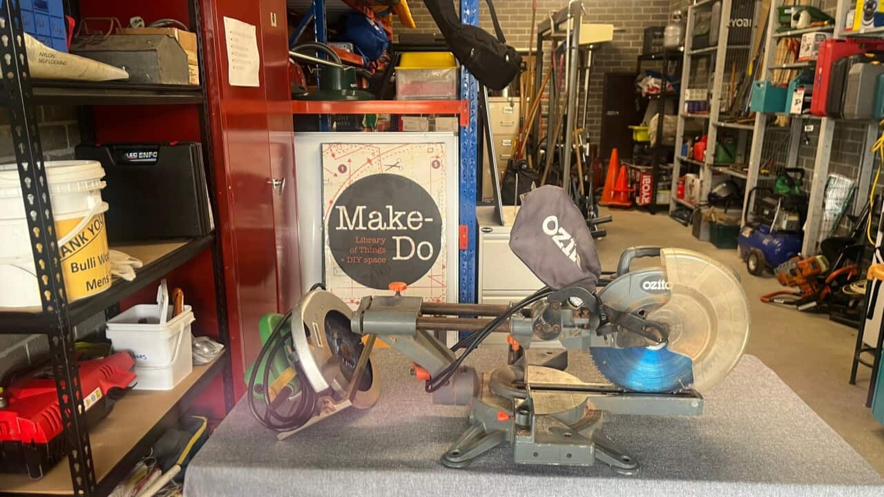 A circular saw on a table at the front of a shed full of items and a sign saying 'Make-Do.'