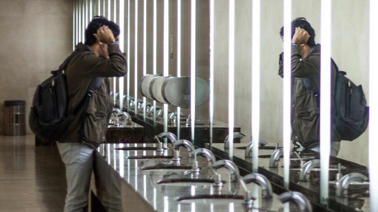 Side View Of Man Standing In Public Restroom