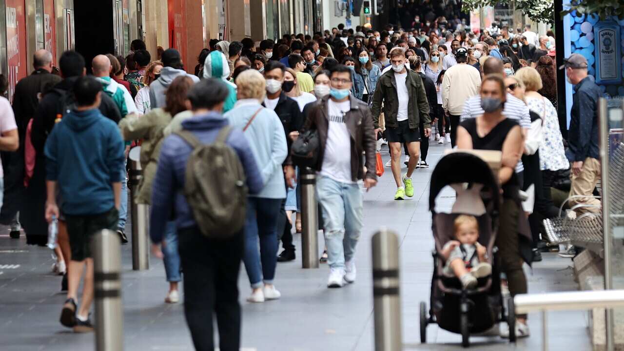 People are seen walking on a street in Melbourne.